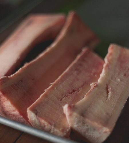 High-quality close-up image of raw beef bone marrow slices on a tray, perfect for cooking concepts.